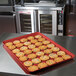 A red MFG Tray bakery display tray with cookies on it.