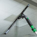 An Unger ErgoTec Ninja squeegee cleaning a glass window.