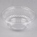 A Dart clear plastic bowl with a curved edge on a white background.