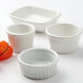 A group of Tuxton bright white rectangle china sauce dishes.