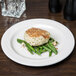 A Libbey ivory porcelain plate with a piece of fish and green beans on it.