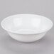 A white Libbey aluma porcelain bowl with a white rim on a gray surface.