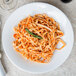 A Libbey white porcelain pasta bowl filled with pasta and sauce.