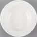A Libbey ivory porcelain fruit bowl with a rim on a gray surface.