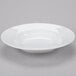 A Libbey white porcelain pasta bowl on a gray surface.