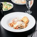 A plate of pasta and salad on a white Libbey porcelain bowl.