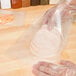 A person holding a plastic bag of sliced turkey.