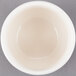 A Libbey ivory porcelain bouillon in a white bowl on a gray surface.