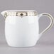 A white pitcher with gold trim on the rim.