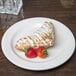 A Libbey ivory porcelain plate with a pastry and strawberries on it.