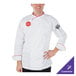 A man wearing a white Mercer Culinary chef coat with red piping.