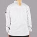 A woman wearing a white Mercer Culinary chef jacket with black piping.