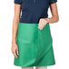 A woman wearing a green Intedge waist apron.