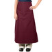 A woman wearing a burgundy Intedge bistro apron.