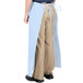A person wearing a long light blue Intedge bistro apron.