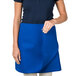 A woman wearing a blue Intedge waist apron.