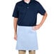 A man wearing a light blue Intedge waist apron over a blue shirt.