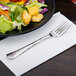 A Libbey stainless steel salad fork on a plate of salad.