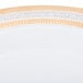 A close-up of a white porcelain dinner plate with a gold rim.