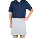 A man wearing a white Intedge waist apron over a blue shirt.