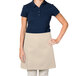 A woman wearing a beige Intedge waist apron.