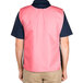 A man wearing a mauve Intedge cobbler apron over a pink vest.