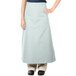 A woman wearing a sea green Intedge bistro apron with 2 pockets.