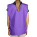 A woman wearing a purple Intedge cobbler apron with pockets.