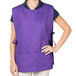 A woman wearing a purple Intedge cobbler apron.
