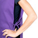 A woman wearing a purple Intedge cobbler apron with black trim.