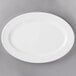 A 10 Strawberry Street BISTRO-22 bright white porcelain oval platter on a gray surface.