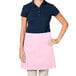 A woman wearing a pink Intedge waist apron.
