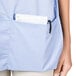 A woman wearing an Intedge light blue cobbler apron with pockets.