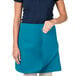 A woman wearing a teal Intedge waist apron.