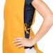 A woman wearing a yellow Intedge cobbler apron with 2 pockets.