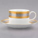 A close-up of a white and gold teacup and saucer.
