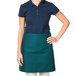 A woman wearing a hunter green Intedge waist apron.