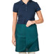 A woman wearing a Hunter green Intedge waist apron.