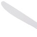 A close-up of a Libbey Neptune dinner knife with a white handle.