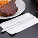 A plate of meat and rice with a Libbey Contempra steak knife on a napkin.