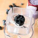 A plastic Waring blending assembly with a black knob on a glass jar.