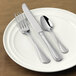 A white plate with Libbey Geneva stainless steel dessert knives on it.