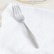 A Libbey stainless steel dessert fork on a white napkin.