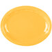 A yellow oval platter with a white border and wavy edges.