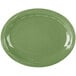 A sage green oval porcelain platter with a carved wavy design on the edge.