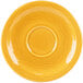 A yellow saucer with a circular pattern on the rim.