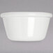 A white Carlisle ramekin on a gray surface.