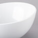 A white Tablecraft Sierra melamine bowl with a white rim on a gray surface.
