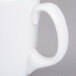 A close-up of a Libbey white porcelain mug with a handle.
