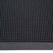 A close-up of a black rubber Cactus Mat with holes in it.
